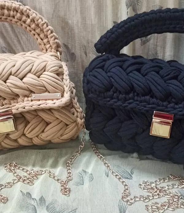 Here are two of my classic t-shirt yarn handbags side-by-side in beige and black. This shows how the same design looks in different versatile colors, both featuring a braided body and a gold-tone chain strap.