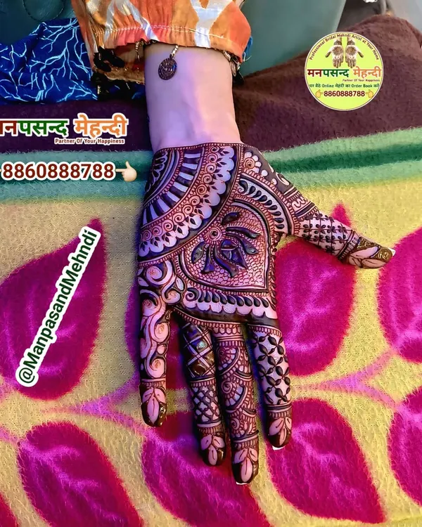 A classic Arabic mehndi design. The pattern flows diagonally across the hand, featuring bold outlines and delicate shading for a beautiful, modern look.