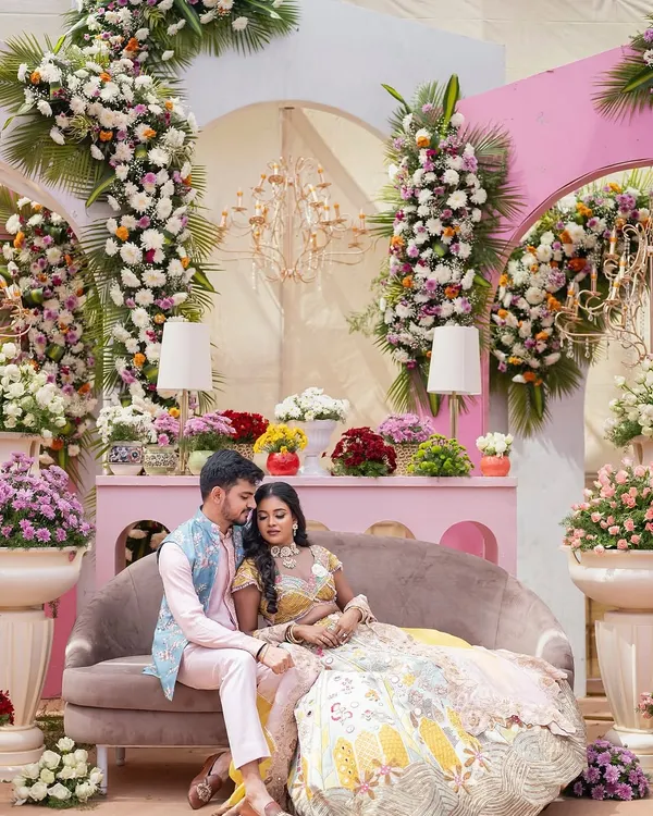 A pastel dream brought to life for a modern couple. This romantic stage setup is enveloped in a cascade of fresh, exotic flowers, creating a scene that feels both grand and deeply personal.