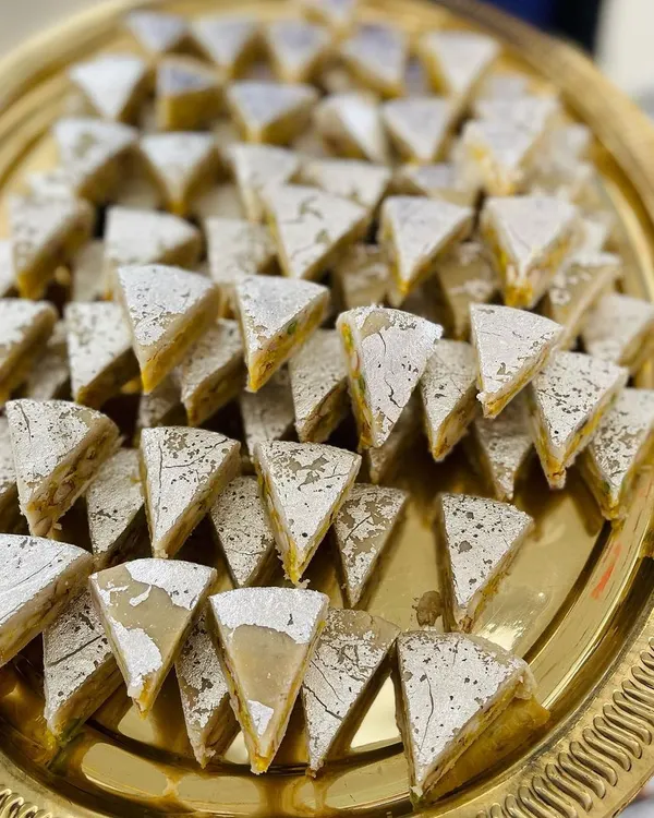 This is our unique Dryfruit Sandwich, a multi-layered sweet that is a feast for the eyes and the palate. It's a popular choice for wedding sweet platters and as a standout item in our assorted gift boxes.