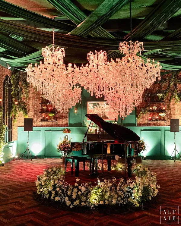 For this contemporary reception in a glass house, I took inspiration from vintage London lofts. The design featured a grand piano as a centerpiece under magnificent crystal chandeliers, with exposed brick walls and lush florals creating a warm, sophisticated, and soulful atmosphere.