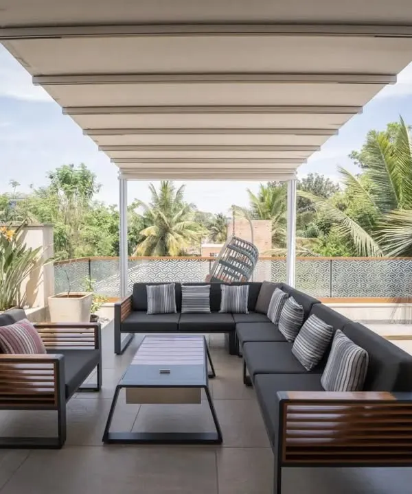 This expansive terrace is designed for gathering. The large, comfortable sectional sofa under a retractable awning creates a perfect outdoor living room for family and friends to mingle and enjoy the view.