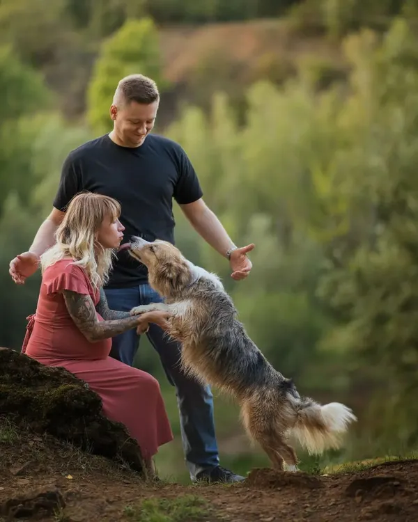 A playful lick from a furry friend during an outdoor maternity shoot. These spontaneous moments of affection are what make photos with pets so special and authentic.
