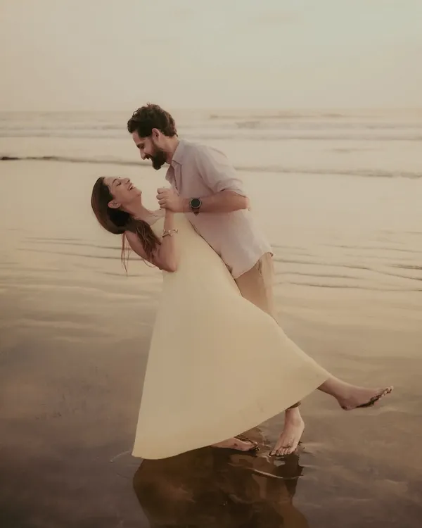 A playful dip and a shared laugh on the wet sand. I love capturing these spontaneous, joyful moments during a pre-wedding beach shoot.