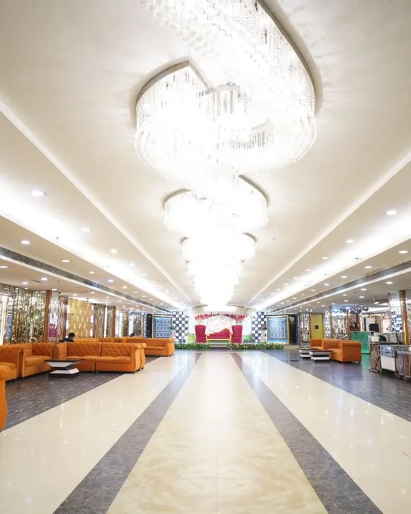 The grand hall of the wedding venue, showing the magnificent chandeliers and spacious layout. Capturing the venue helps set the scene for the entire event.