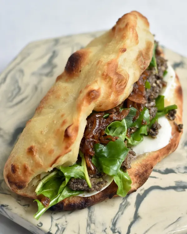 Our Mushroom Duxelles Sourdough Pizza Sandwich from the Spanish mini-edit. It's packed with flavor from caramelized onions, arugula, mozzarella, and a hint of truffle oil.