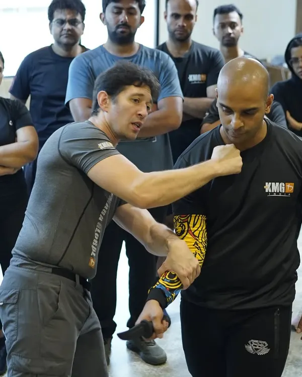 This is the reality of what we prepare you for. Here, a visiting KMG expert demonstrates a fundamental knife defense technique, focusing on control and disarming. Our curriculum is built on providing practical, life-saving skills for worst-case scenarios.