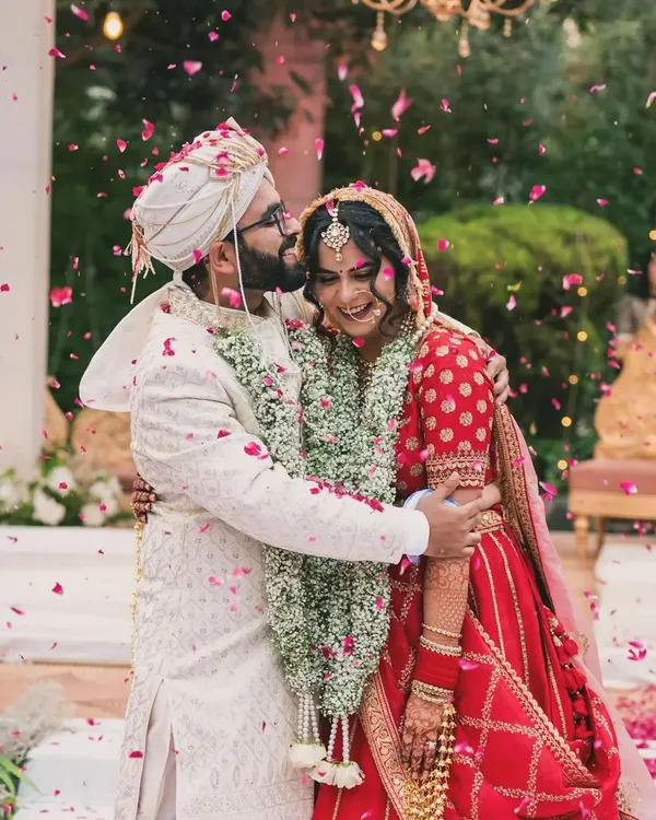 This is the moment that matters most. The pure, unscripted joy of a couple, showered in petals, right after the varmala ceremony. I live for capturing these candid wedding day memories.