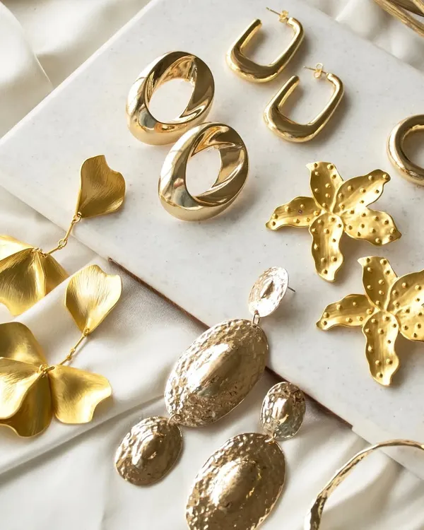 Make a statement without saying a word. This flat lay showcases some of my favorite bold, gold earrings, including spiral groovy ovals, floral drops, and abstract hoops.