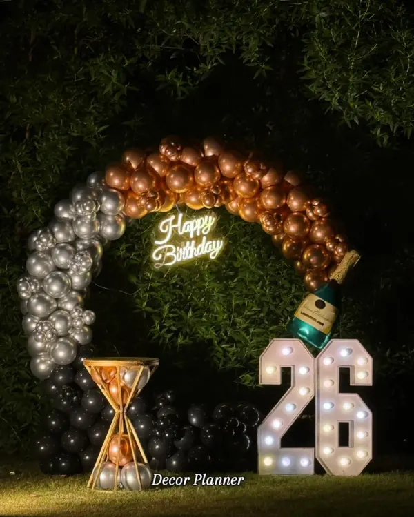 This stunning outdoor setup for a 26th birthday is a perfect example of modern, chic celebrations. The glowing marquee numbers, combined with a stylish balloon arch and a neon sign, create an unforgettable photo opportunity and a sophisticated party atmosphere under the stars.