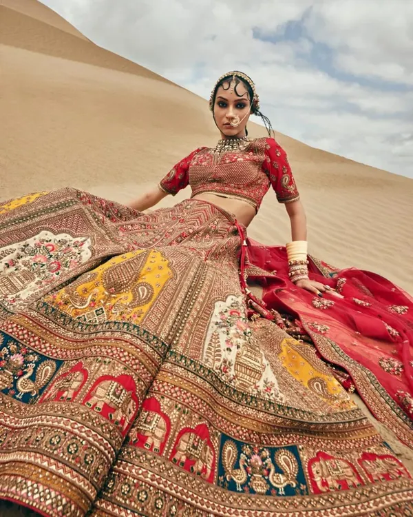 This is one of my most stunning pieces for a royal pre-wedding shoot. The skirt features intricate doli and peacock embroidery in multiple colors, making it a true statement lehenga for creating unforgettable photos.