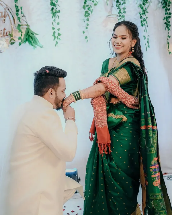 A beautiful moment of chivalry and tradition during an engagement ceremony. The groom kissing the bride's hand is a timeless gesture of love and respect, captured here with her joyful smile.