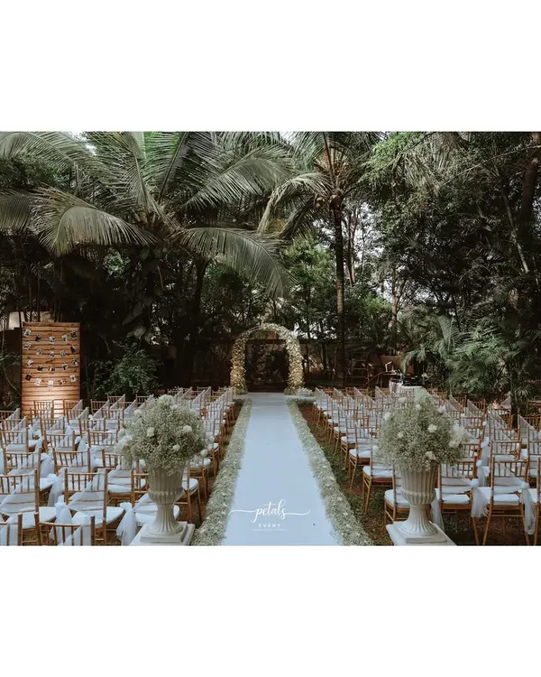 A soft white dream for a Christian wedding. The aisle is lined with baby's breath, leading to a romantic floral arch, with Victorian vases adding a touch of classic elegance.