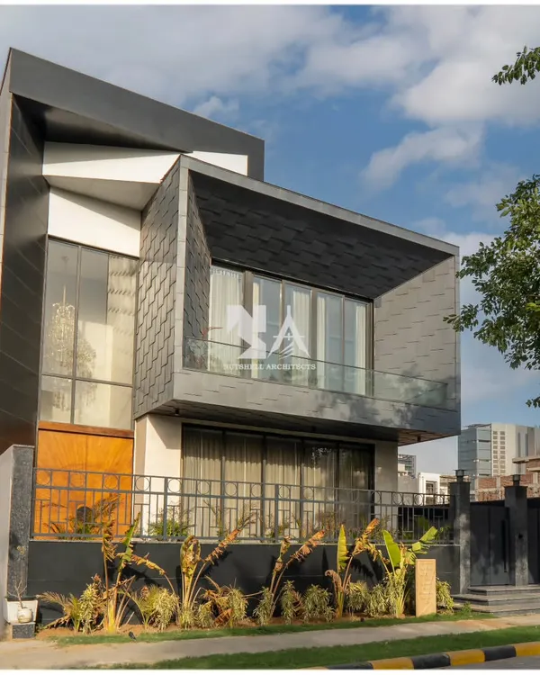 This is our award-winning residence in DLF Alameda, a project that defines our approach to modern luxury. The facade features striking zinc shingles that create a dynamic, textured surface, contrasted with large glass panels and a strong geometric form. We designed this home to be a landmark, balancing visual impact with a sense of privacy and sophistication.