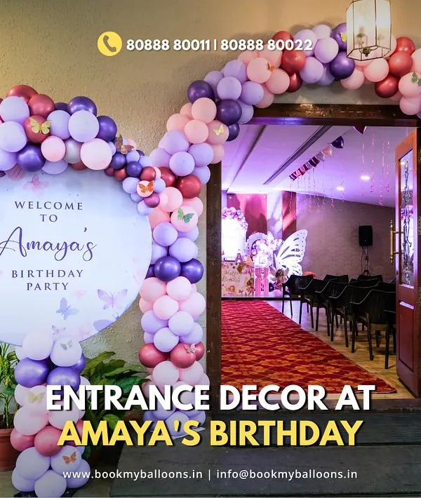 The entrance decor for Amaya's butterfly party sets a magical tone from the moment guests arrive. A beautiful balloon arch in shades of purple and pink frames a custom welcome sign, creating a grand and inviting entryway.