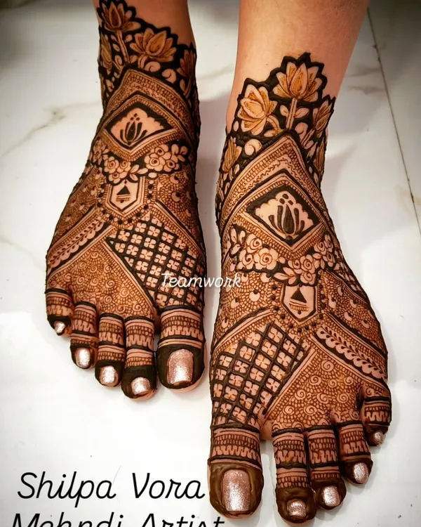 A classic bridal foot design featuring lotus motifs and a heavy jaal (net) pattern. The symmetry and clean lines are key to this look.