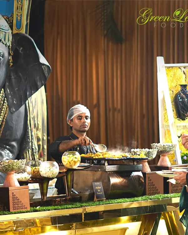 Live counters are the heart of the party. Here, our chef is preparing a sizzling dish for a guest at a beautifully decorated counter, showing the interactive and engaging experience we provide at weddings and other events.