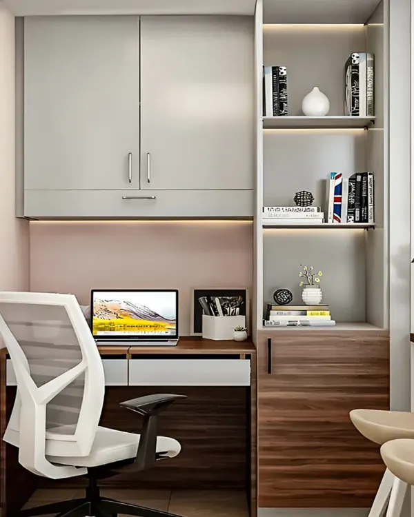 A compact study nook carved out of a small space. It features overhead cabinets and open shelving with integrated lighting.