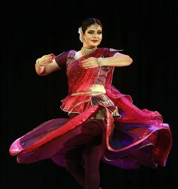 A senior artist demonstrates the dynamic 'chakkar' or spin, a hallmark of Kathak dance. Our advanced classes focus on perfecting such techniques with speed, grace, and precision.