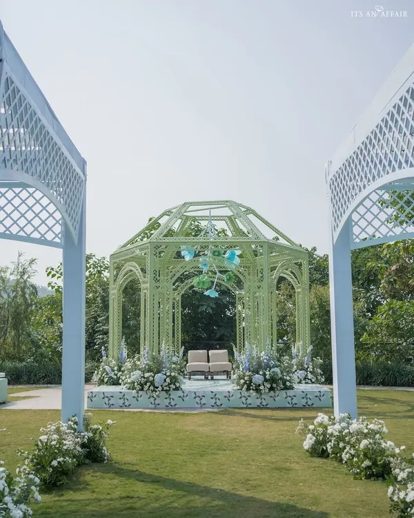 A modern Anand Karaj ceremony in Dehradun, featuring a mint green gazebo-style mandap. The design is clean and contemporary, with a backdrop of the mountains.