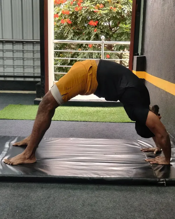 Flexibility is a journey, not a destination. This student is working on his backbend, or wheel pose, to improve spinal mobility and strength.