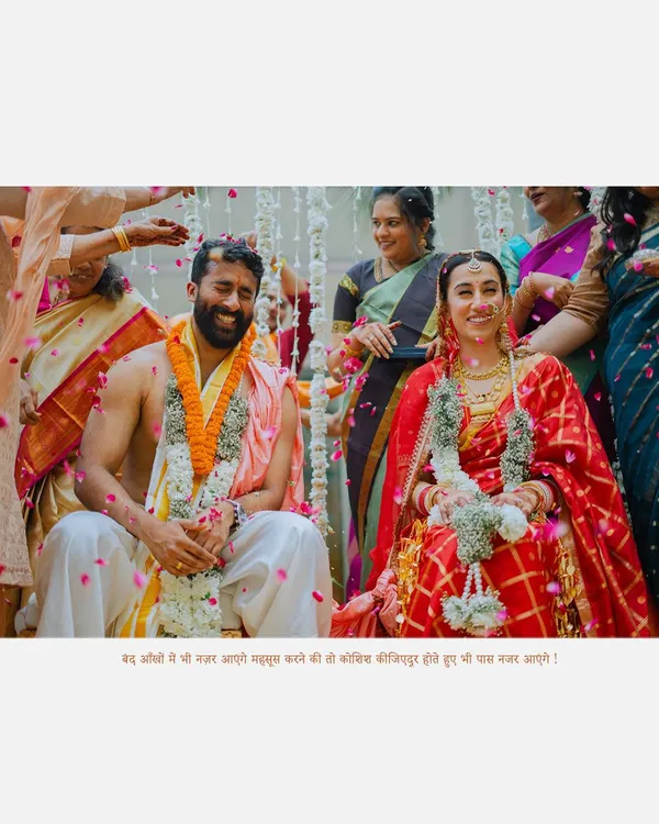 A beautiful moment from a South Indian wedding ceremony, capturing the couple's joy as they are showered with blessings and petals by their families.