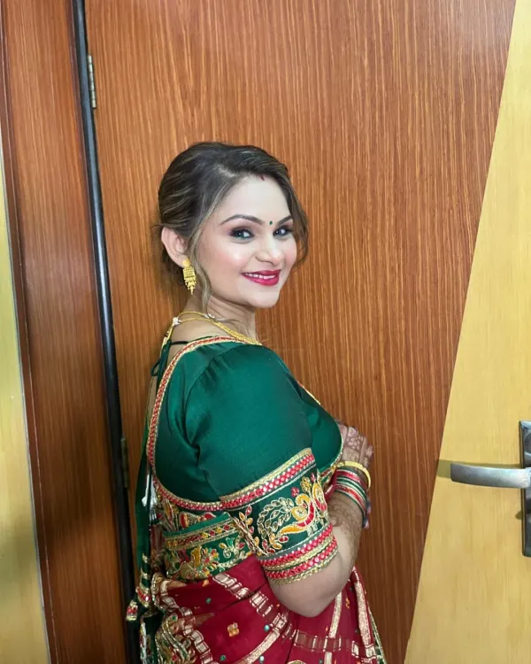 A beautiful client ready for a wedding. Her makeup is elegant and sophisticated, with a classic red and green saree.