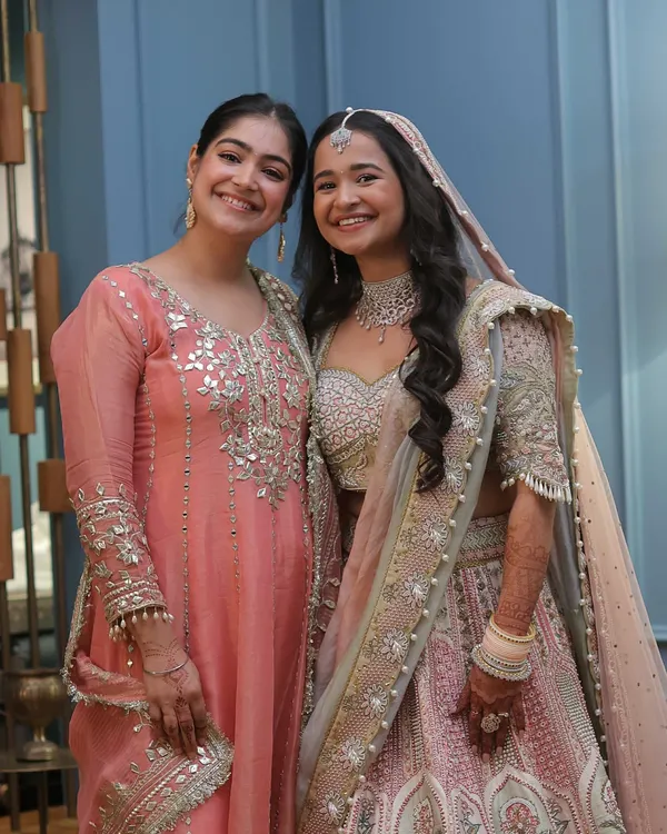 A beautiful moment with a bride I styled. I'm wearing a peach suit with mirror work, a great option for a wedding guest attending a day function, while the bride looks radiant in her pastel lehenga.