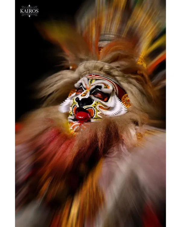 A dynamic, zoom-burst photograph of a Kathakali performer, creating a sense of intense motion and focusing on the powerful facial expression. This is an example of my creative event photography.