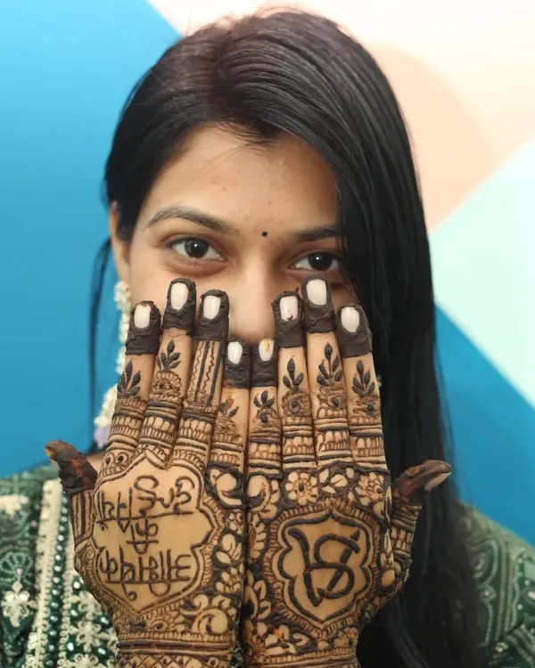 A close-up of the bride showcasing her full mehandi design, including the couple's initials hidden within the pattern. We make sure to capture these personalized details.