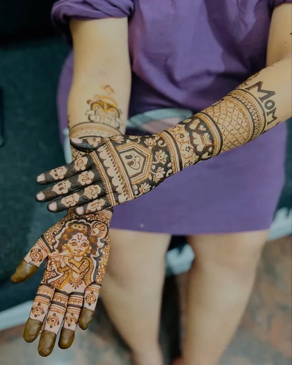 One of my most requested baby shower designs, featuring a playful baby Krishna on one palm and "MOM" written on the forearm. It’s a beautiful blend of tradition and modern celebration.