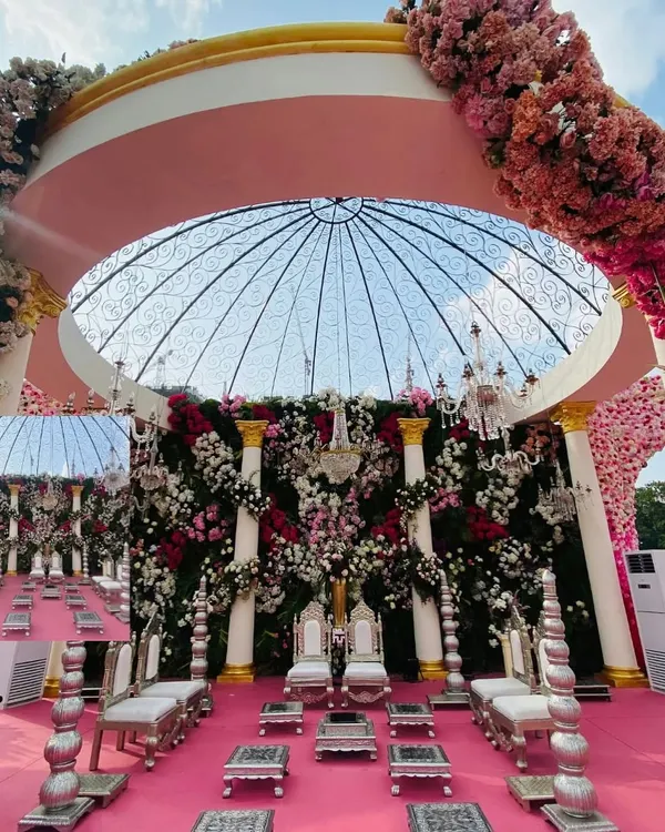 For this spectacular wedding, I designed a mandap that was a true floral masterpiece. A transparent dome structure is adorned with a dense canopy of pink, white, and red flowers, creating a heavenly space for the ceremony. The silver traditional seating adds a touch of regal elegance.