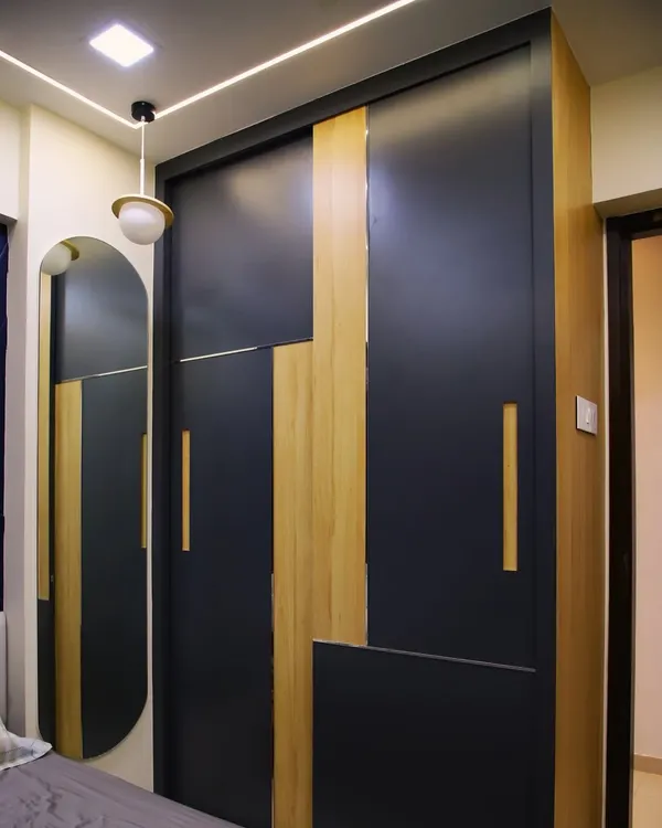 A modern sliding wardrobe with a striking geometric pattern of dark laminate and wood finish, combining bold design with practical storage.