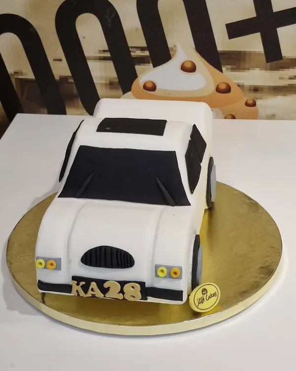 A sleek 2.5kg custom cake sculpted to look like a white car, complete with a personalized license plate.