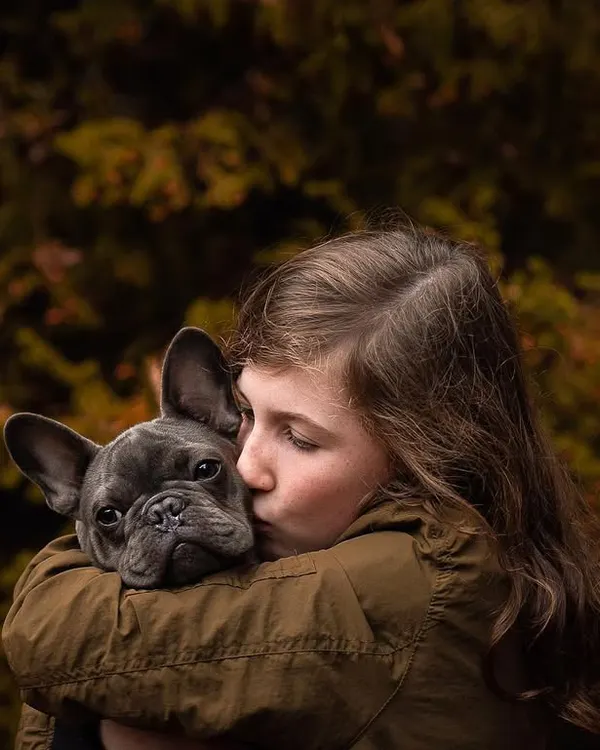 A moment of pure, gentle love. A girl gives her French Bulldog a sweet kiss on the head. This is the kind of candid, heartfelt image that I dream of capturing.