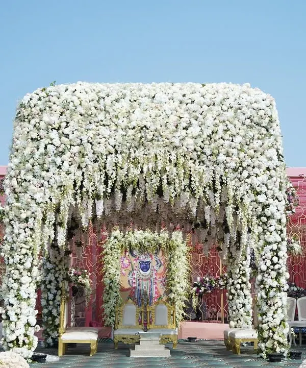 This breathtaking mandap, completely enveloped in a cascade of pristine white florals, creates a heavenly sanctuary for exchanging vows. It’s a perfect example of our ‘Ivory Paradise’ theme, designed to feel like a dream come true.