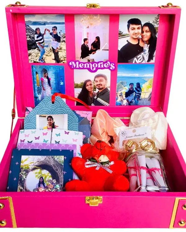 A birthday gift that holds a lifetime of memories. This beautiful pink trunk hamper opens to reveal a collage of 18 photos, along with scrunchies, earrings, a teddy, and a jar of "reasons why I love you" notes.