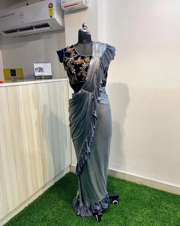 This ready-to-wear saree is the perfect blend of modern and traditional. It features a beautifully embroidered velvet blouse paired with a pre-stitched ruffled saree for a hassle-free, glamorous look.