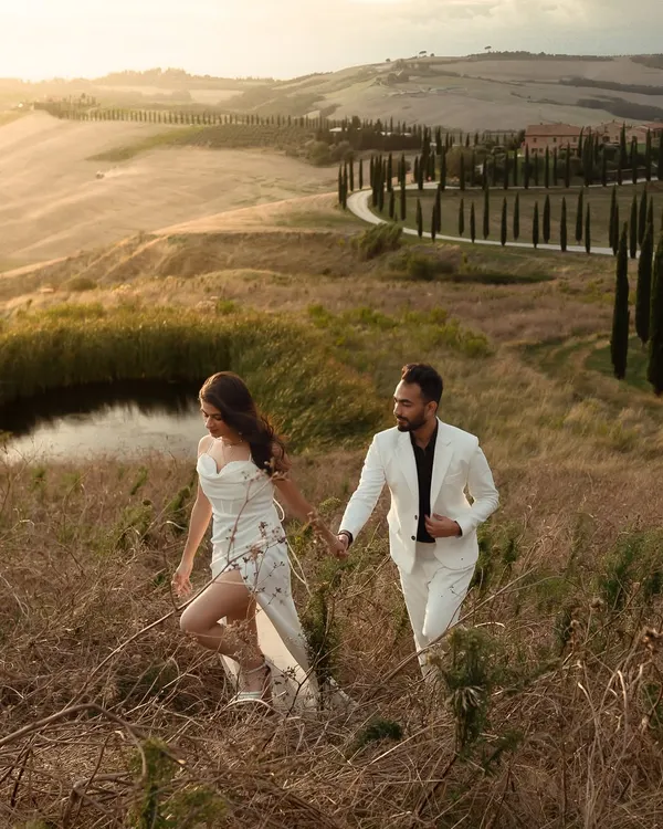 Exploring the golden, rolling hills of Tuscany. This shot of Nisarg and Mansi captures the feeling of a romantic escape, hand in hand, in one of the most beautiful landscapes in the world.