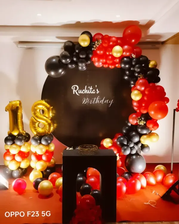 Stepping into adulthood with style! We created this bold and elegant setup for Ruchita's 18th birthday, using a dramatic red, black, and gold color scheme with a circular balloon garland and foil number balloons.