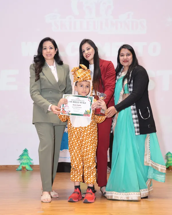 A proud moment on stage at our Christmas show. One of our little performers, dressed as a reindeer, receives her award and certificate from our esteemed chief guests.