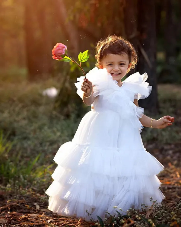 A princess in the woods! The warm, glowing light of the golden hour makes outdoor portraits like this one feel so magical. This little girl's smile and her beautiful white dress are just perfect against the natural backdrop.