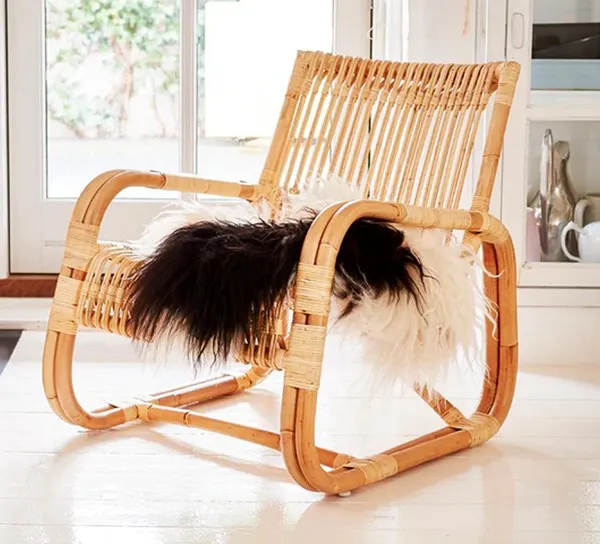 This is a classic low-slung lounge chair made from natural rattan. Its ergonomic design and sturdy, bent-cane frame make it a very comfortable and durable seating option.