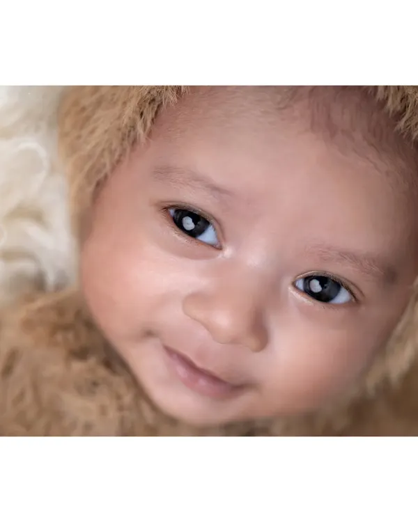 That first little smile is absolutely priceless. This close-up shot captures the bright eyes and sweet expression of an awake and happy baby, showing a glimpse of the wonderful personality that is just beginning to shine through.