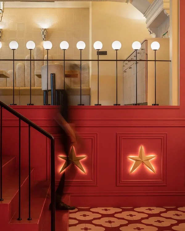 At Masala, New Delhi, the bold red staircase is accented with custom star-shaped wall lights. This detail adds a touch of whimsy and guides guests upward, setting a celebratory tone from the moment they enter.