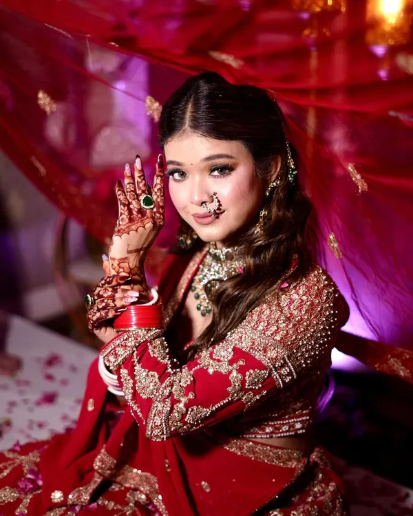 A complete bridal look for a client in a stunning red lehenga. I focused on creating sharp, defined eyes and a radiant base that looks flawless in photos, complementing her traditional jewelry and henna.