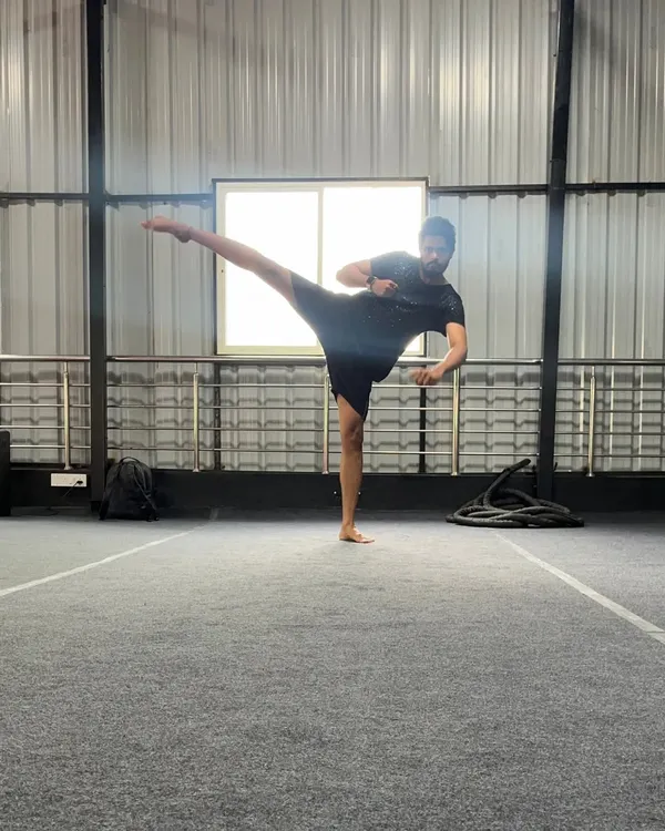 A student holds a perfect side kick, demonstrating excellent balance, flexibility, and control. This is a fundamental kick in many martial arts.
