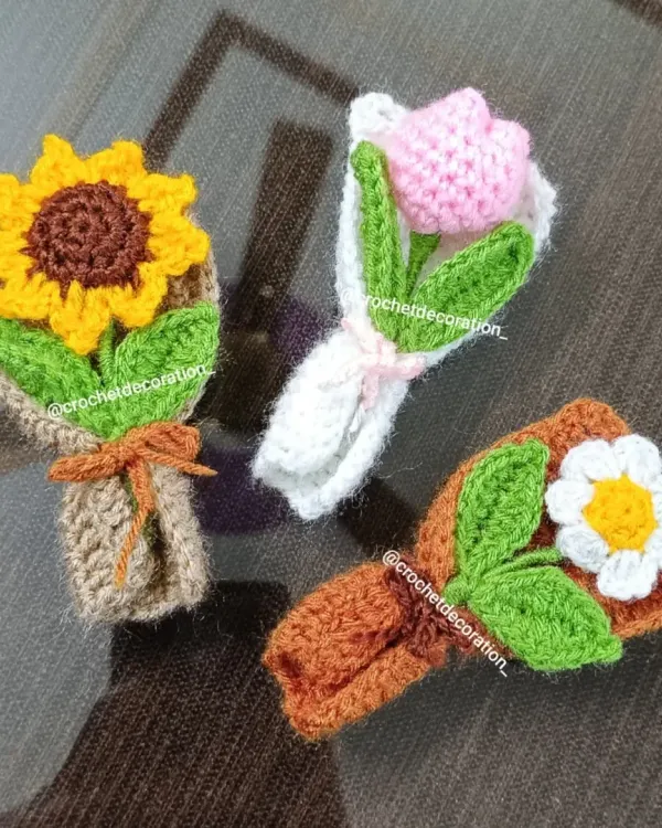 A trio of our extra-small, handmade crochet bouquets. This set includes a cheerful sunflower, a delicate pink tulip, and a classic white daisy, each wrapped and tied with a bow. These everlasting flowers make perfect, long-lasting gifts.