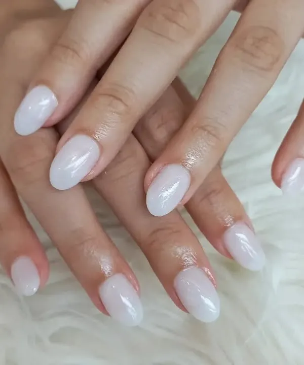 The perfect "your nails but better" look. This manicure features a sheer, milky white polish on beautifully shaped oval nails for a clean, healthy, and natural appearance.