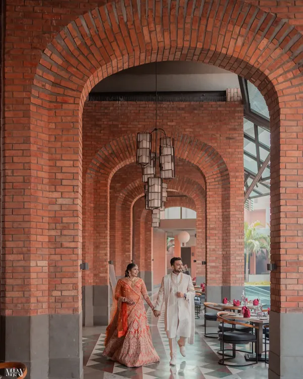 A stunning example of using architecture to create a powerful image. The couple walks hand-in-hand through a corridor of brick arches at Avadh Utopia, with the repeating patterns drawing the eye towards them.